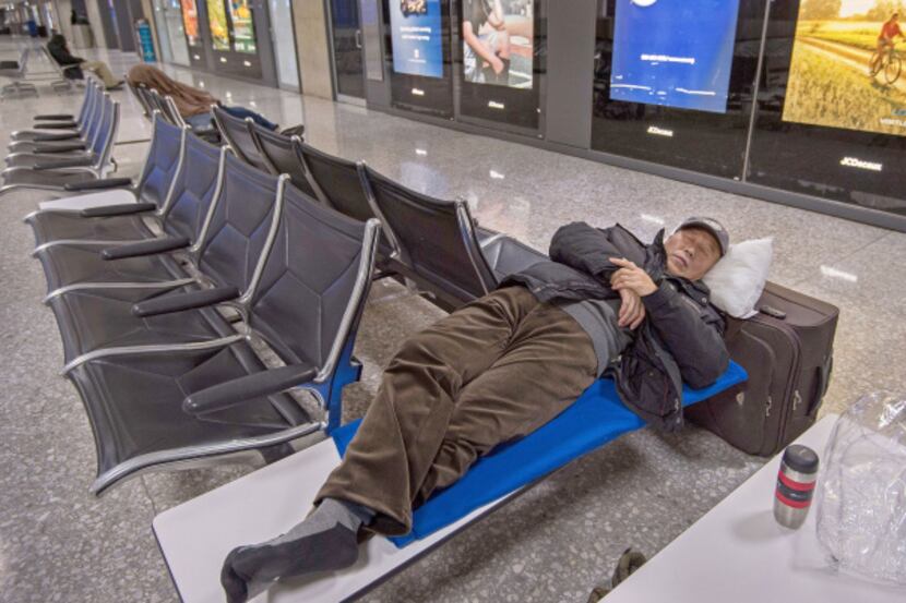 Travelers stranded by the East Coast snowstorm slept in the baggage claim area at Dulles...