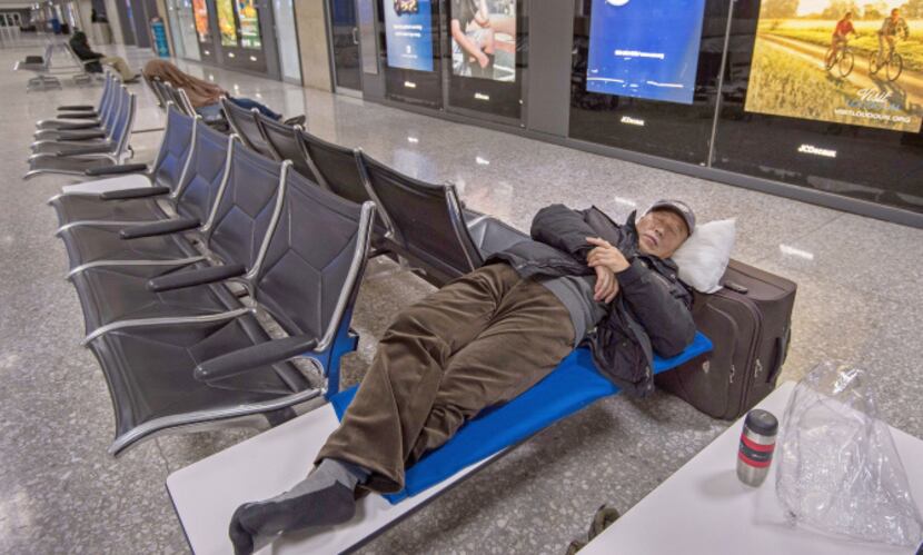 Travelers stranded by the East Coast snowstorm slept in the baggage claim area at Dulles...
