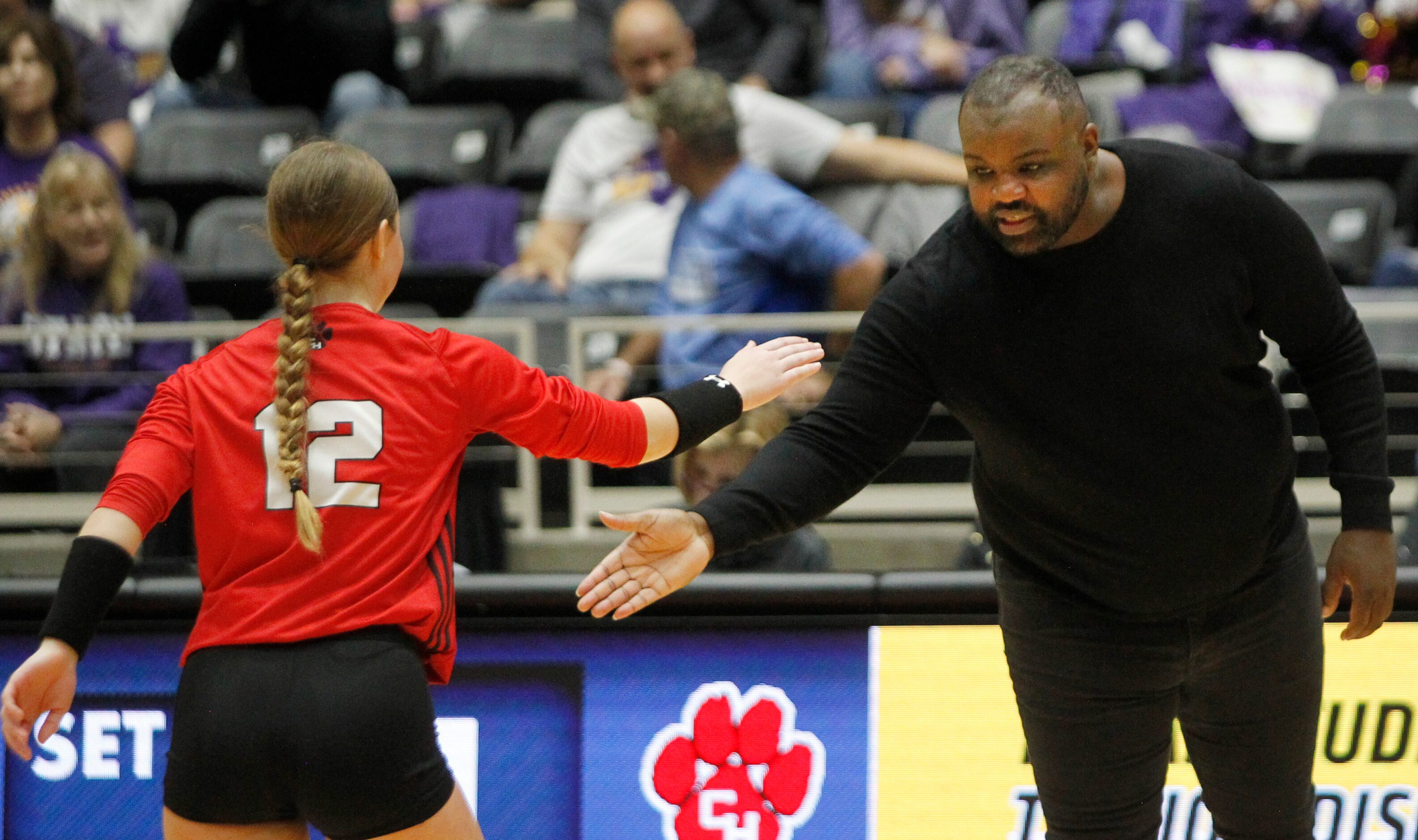 Colleyville Heritage head coach Joshua Kennedy congratulates Claire Bundy (12) after a score...