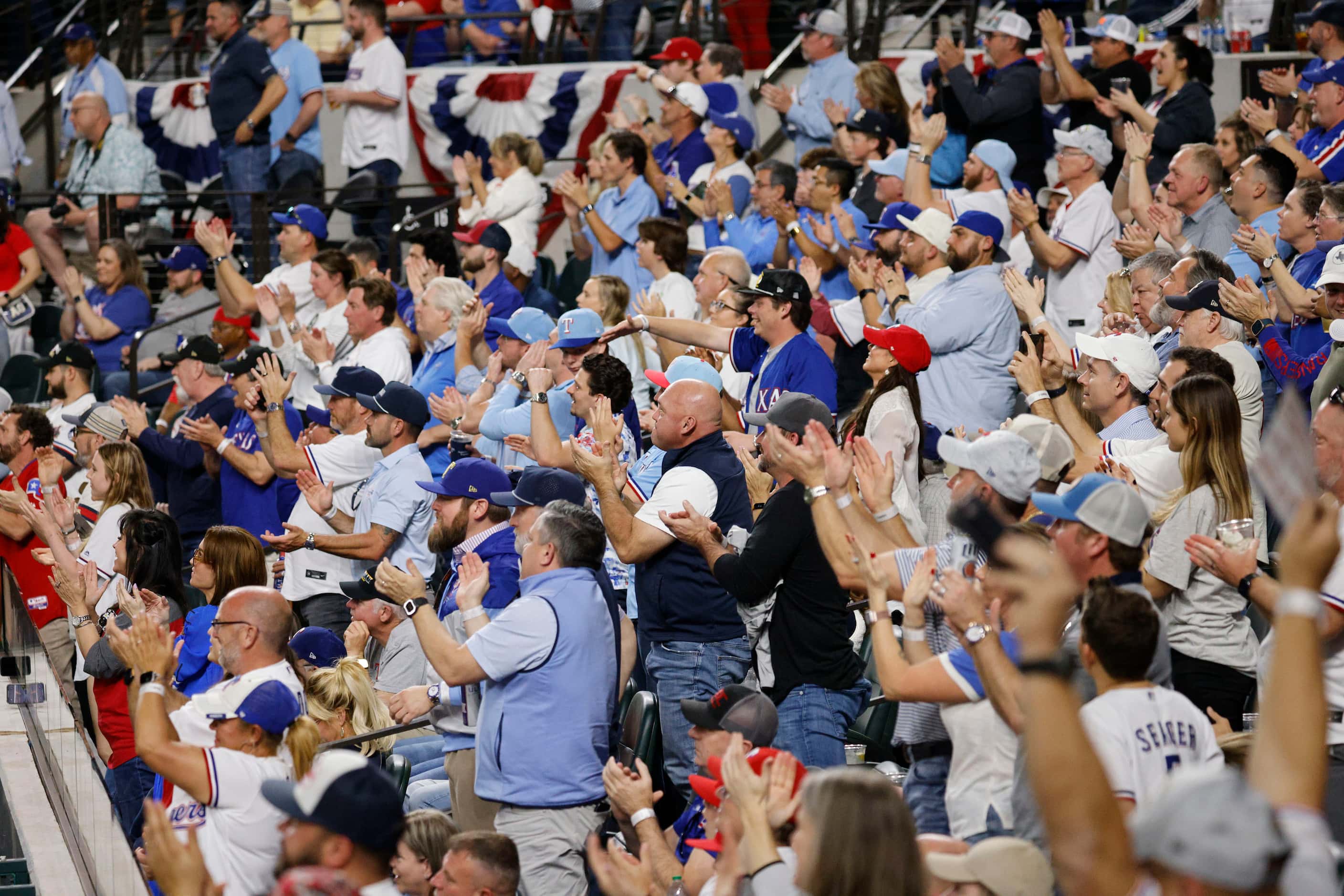 Fans cheer during the sixth inning of the Texas Rangers opening day baseball game against...