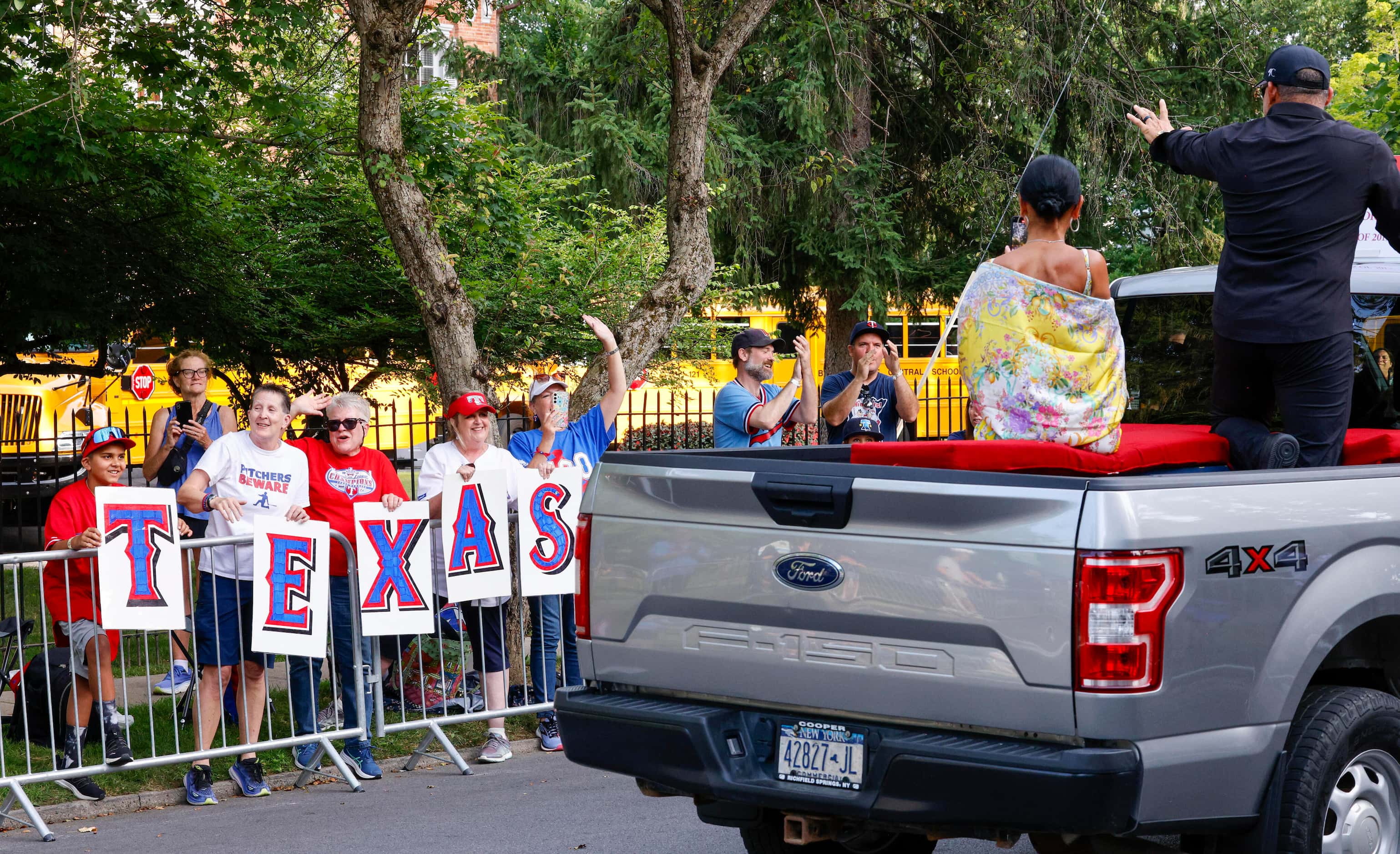 Texas Rangers fans cheer as Hall of Famer Ivan 'Pudge' Rodriguez waves alongside his wife...