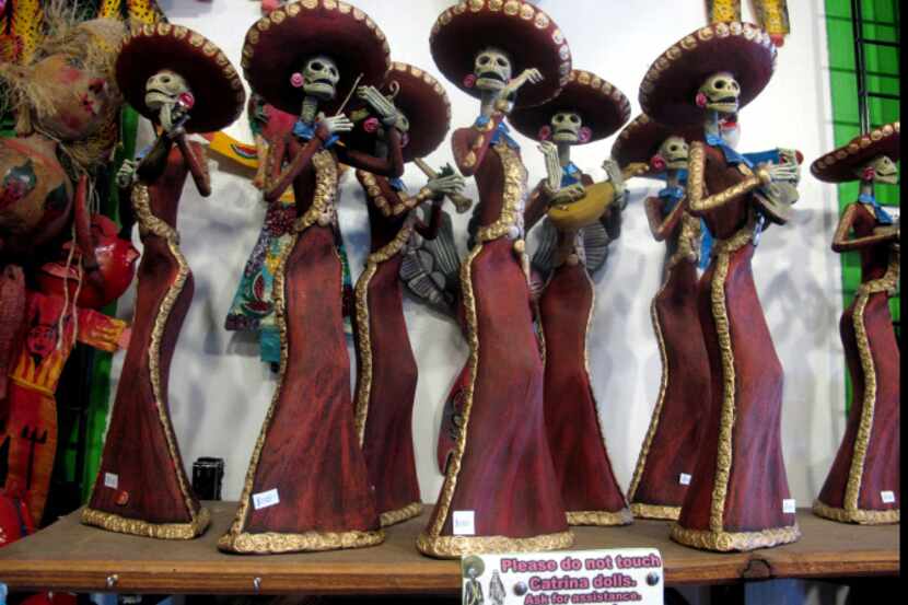 Shops in Albuquerque, N.M., stock Day of the Dead art -- such as these Catrina figures at...