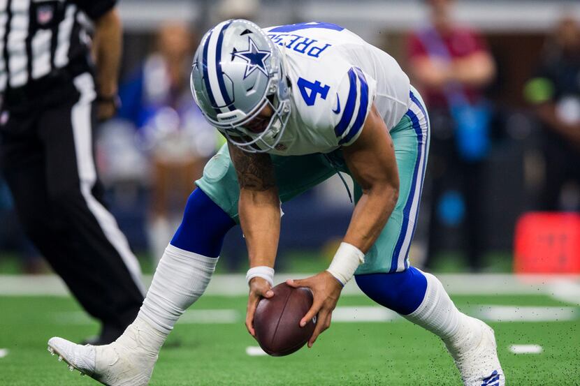 Dallas Cowboys quarterback Dak Prescott (4) recovers a fumble before throwing a pass during...