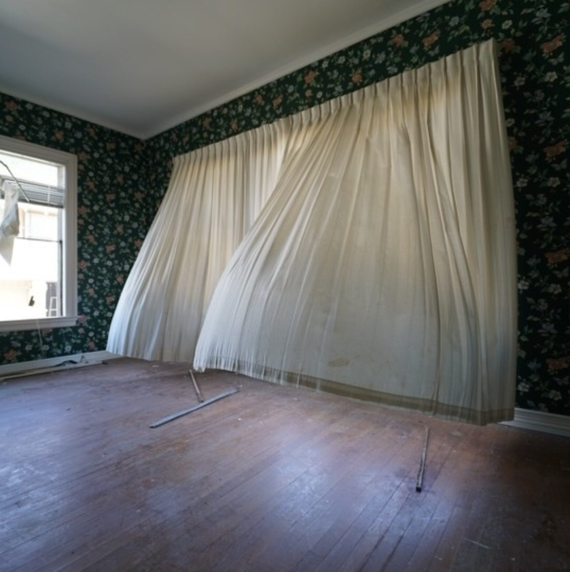 Curtains billow inside an abandoned house in Bishop Arts District.