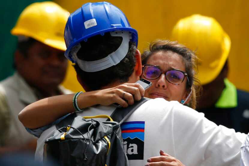 Un rescatista abraza a la novia de Jorge Gómez, de España, quien espera en un lugar de...