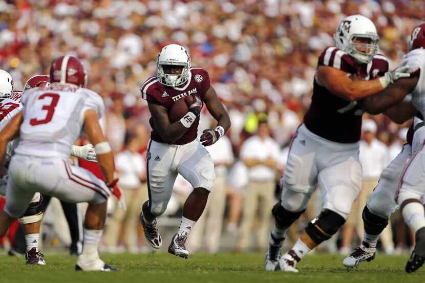 Texas A&M Aggies running back Tra Carson (21) finds a hole in the Alabama defense on a carry...