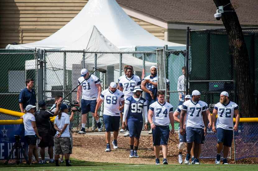 Dallas Cowboys players, including center Travis Frederick (72), tackle Tyron Smith (77),...