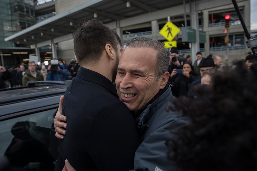 Hameed Khalid Darweesh, center, a former interpreter for the U.S. military in Iraq, embraces...