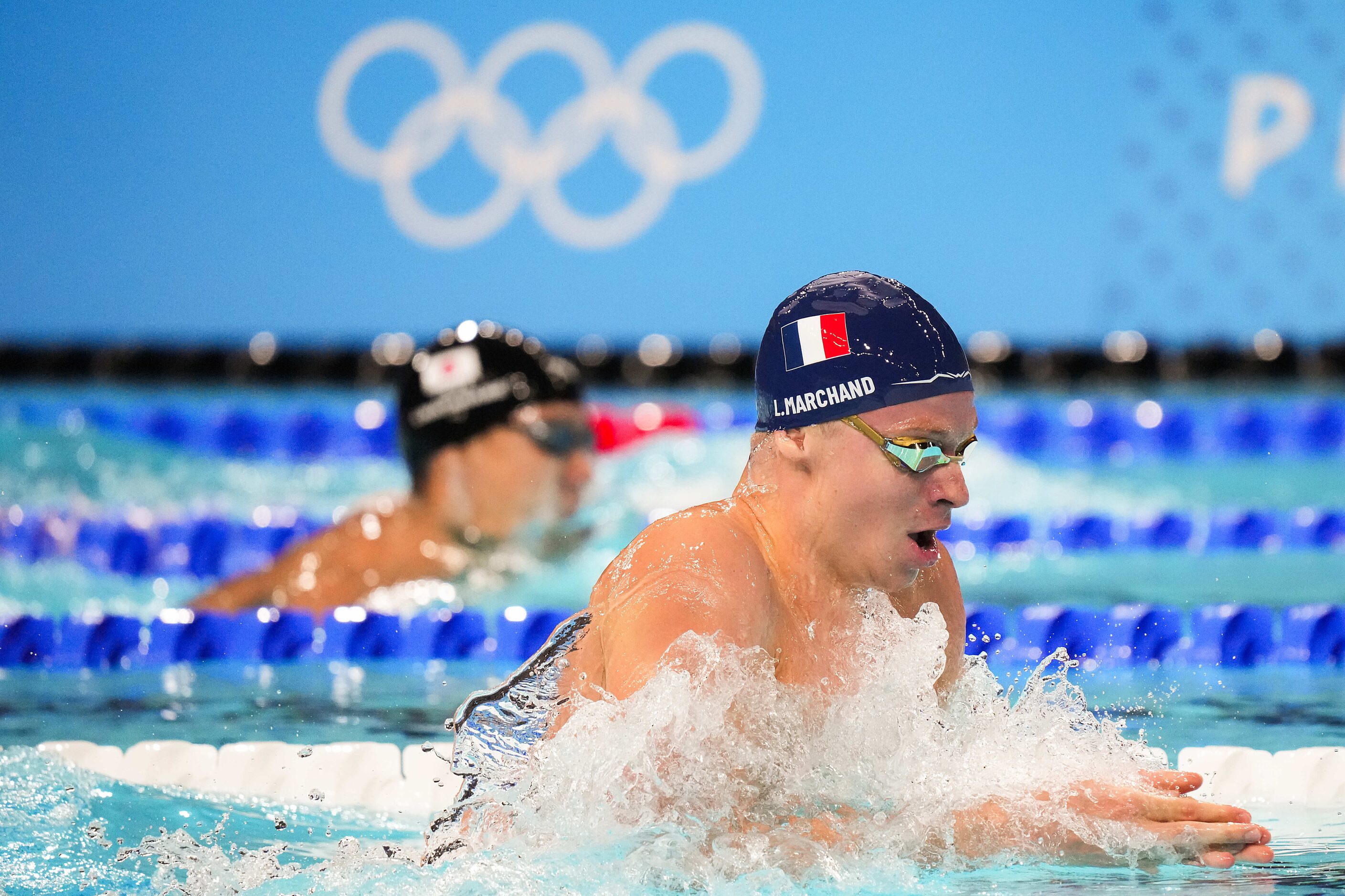 Fans cheer Leon Marchand of France swims in the men’s 200-meter breaststroke final at the...