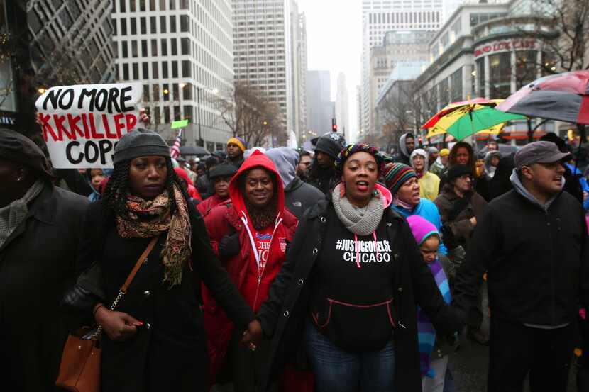 People gather during a demonstration billed as a "march for justice" on Friday, Nov. 27,...