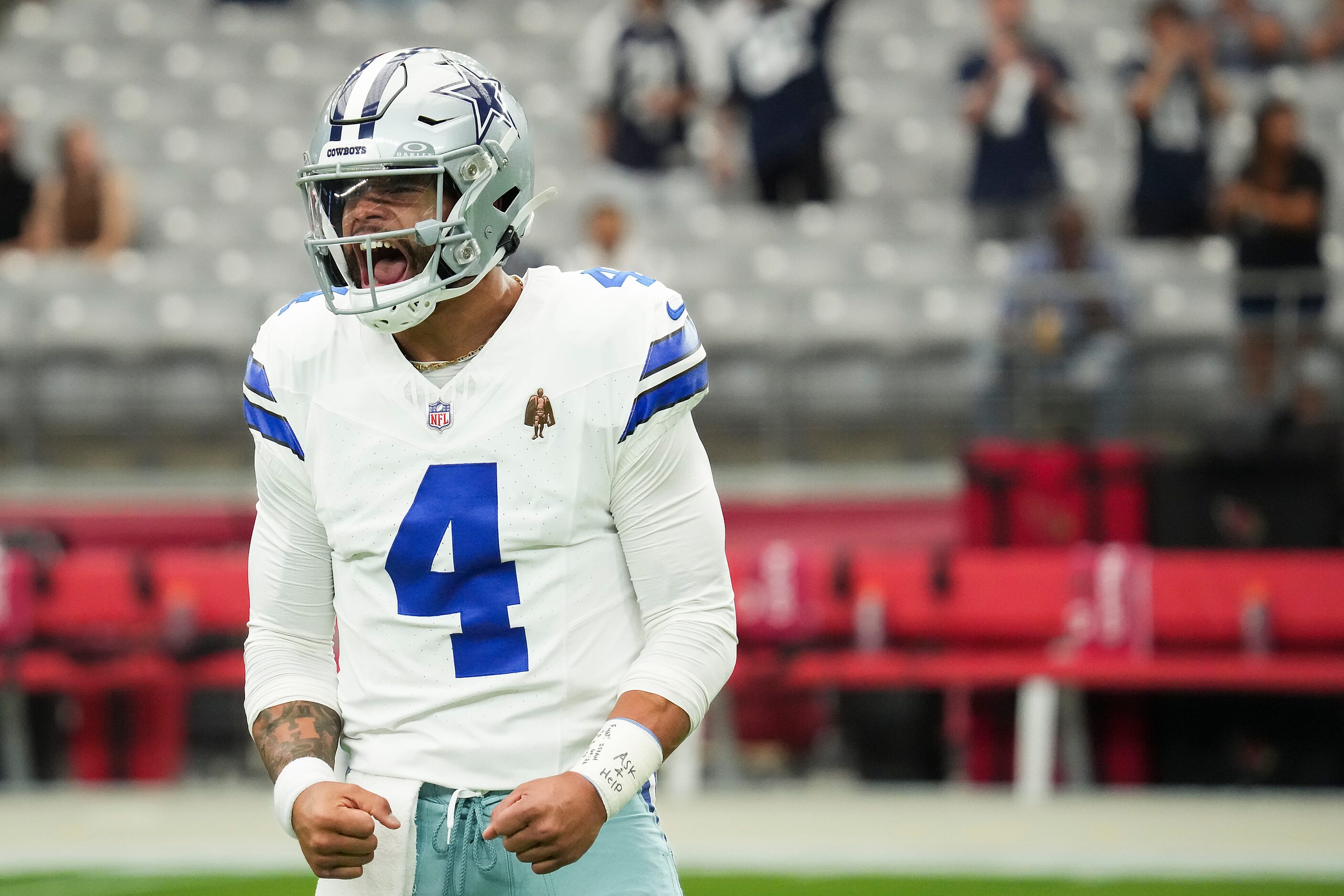 Dallas Cowboys quarterback Dak Prescott lets out a yell as he takes the field to warm up...