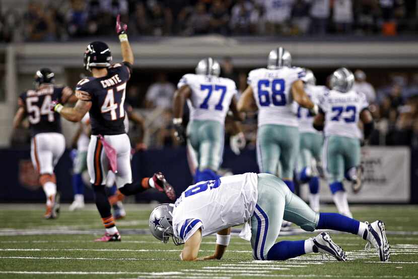 Dallas Cowboys quarterback Tony Romo is slow to get up after his tipped pass was intercepted...