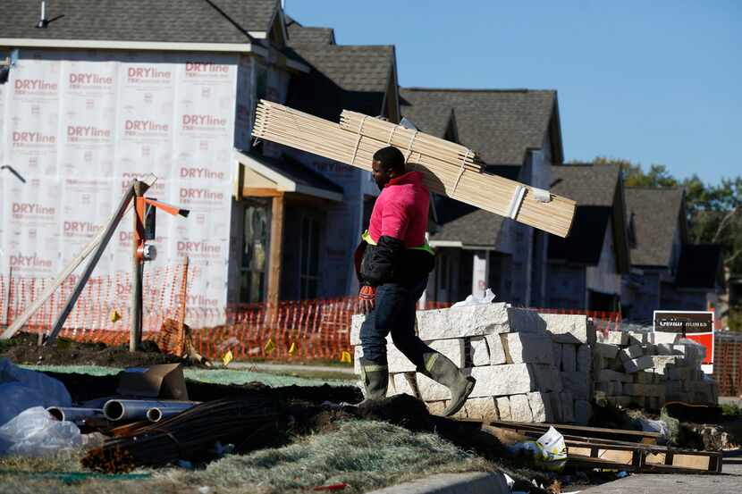 Friday James takes materials into a house under construction by Gehan Homes in 1600 block of...