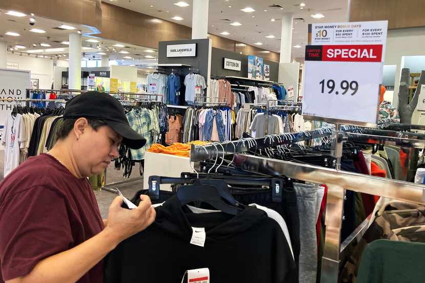 A customer checks price tags while shopping at a retail store in Schaumburg, Ill., on June 30.