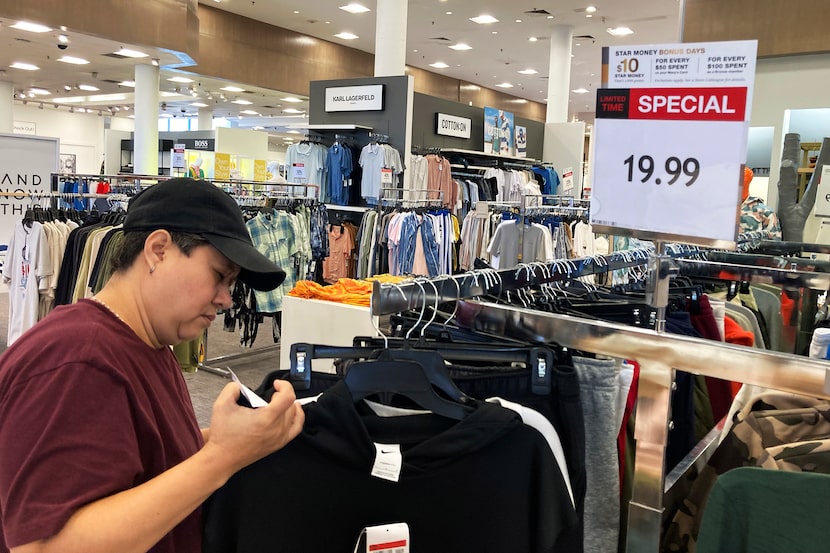 FILE - A customer checks price tags while shopping at a retail store in Schaumburg, Ill.,...