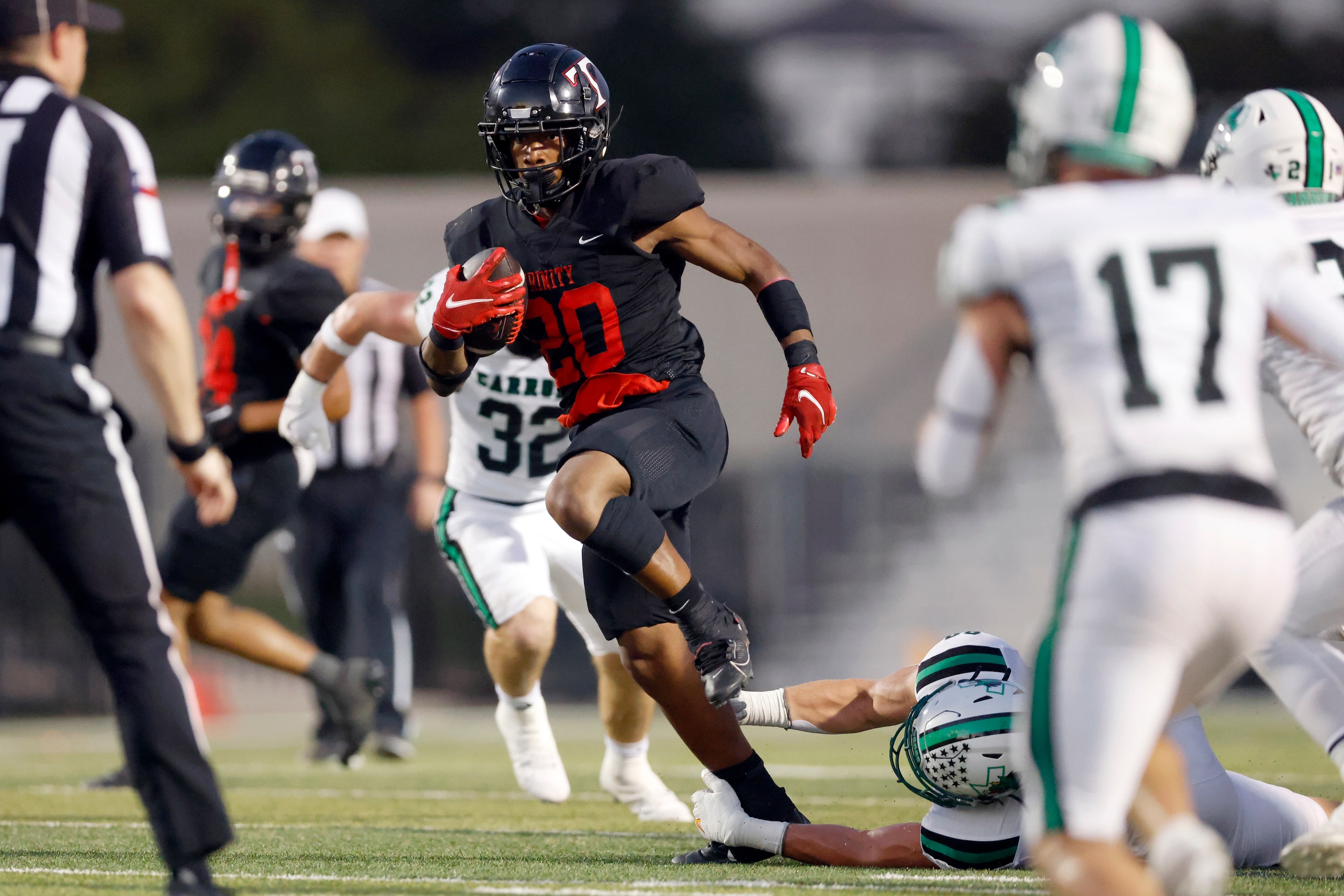 Euless Trinity running back Josh Bell (20) runs through a tackle during the first half of a...