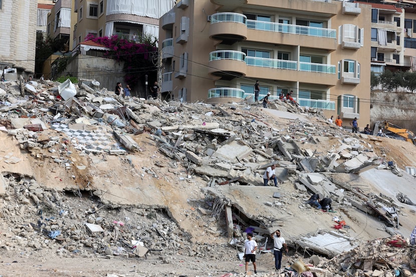 People inspect the damage Monday in the city of Ain Deleb, after an Israeli attack on Sunday.