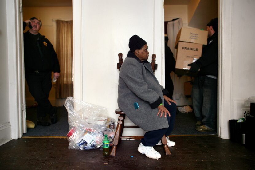 Gloria Rhodes, 64, watches as employees of Eagle Moving and Storage Company remove the...