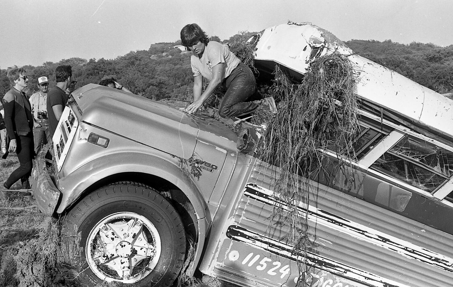 Workers inspect the bus after pulling it from the water.