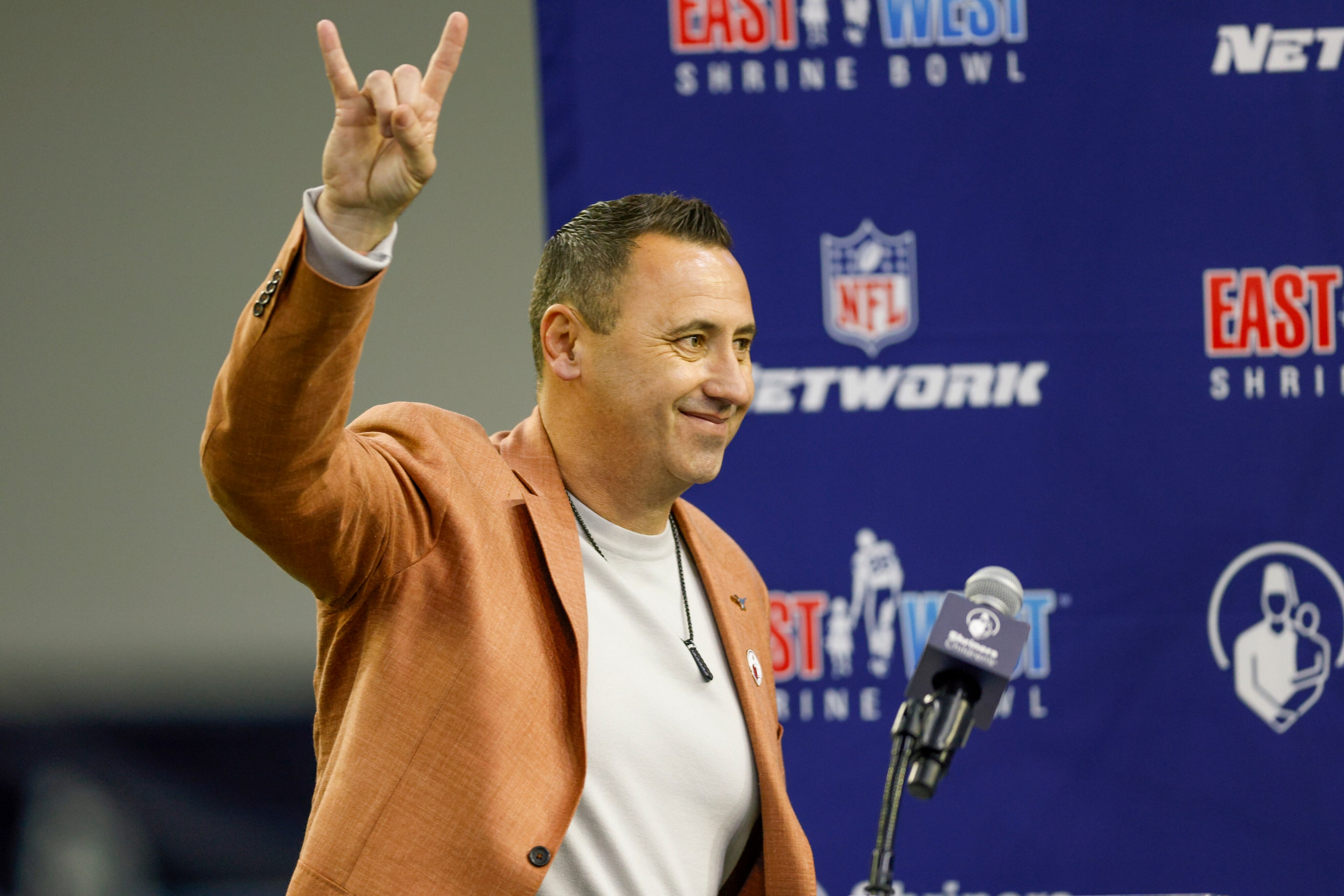 Texas Longhorns head coach Steve Sarkisian gives the Hook 'em Horns sign during an East-West...