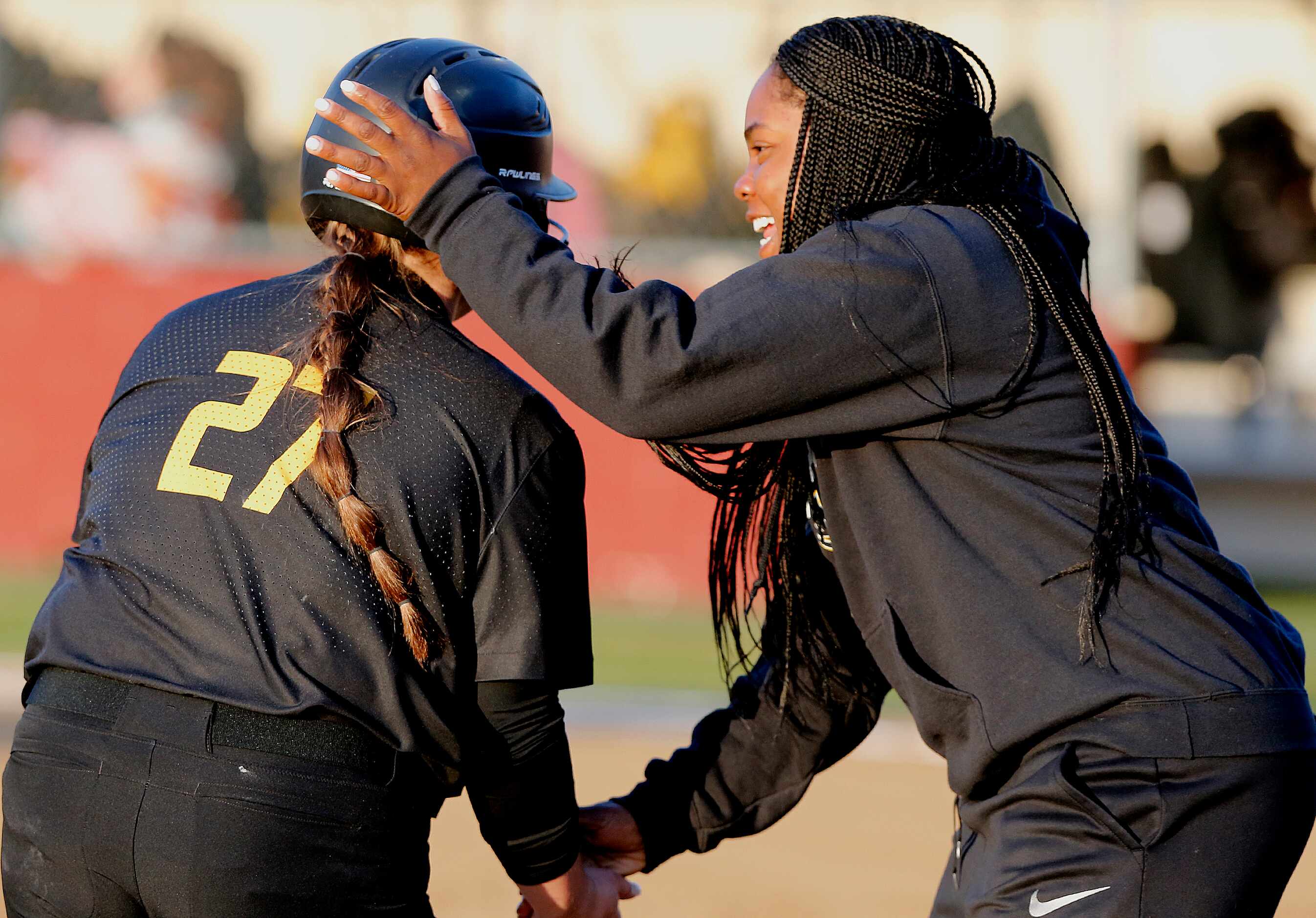 Memorial head coach Porscha Albert congratulates first baseman Peyton Chianese (27) after...