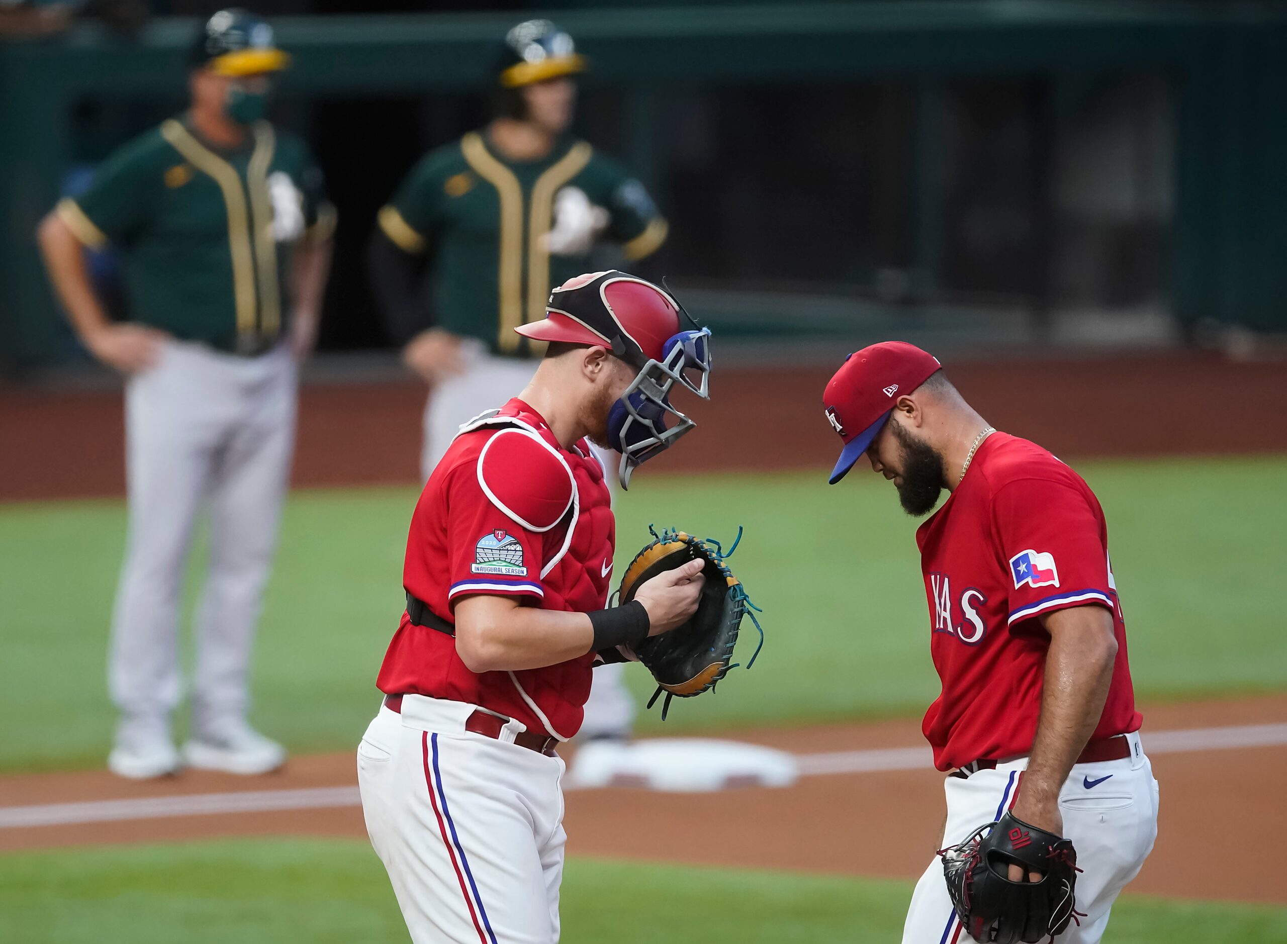 Texas Rangers pitcher Luis Garcia gets a visit from catcher Sam Huff after walking the bases...