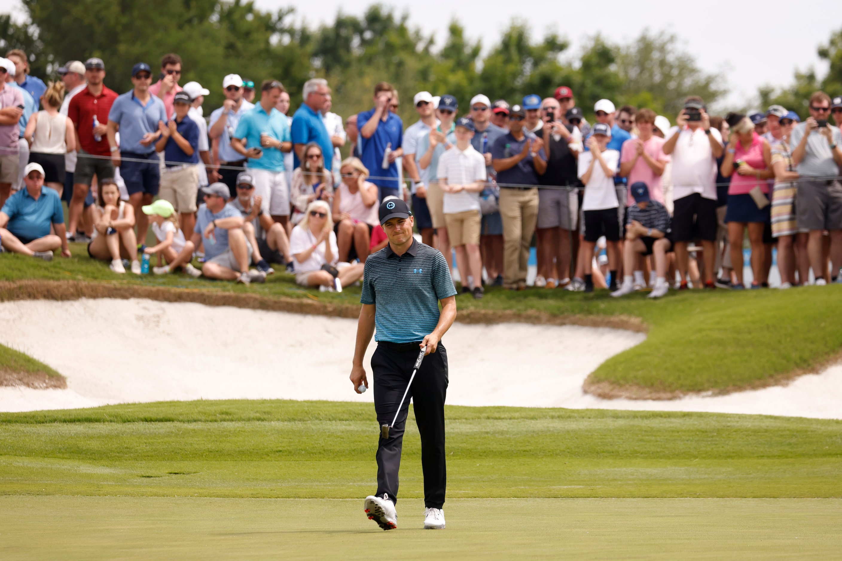 Jordan Spieth acknowledges the crowd after getting a birdie on the 12th hole during round 3...