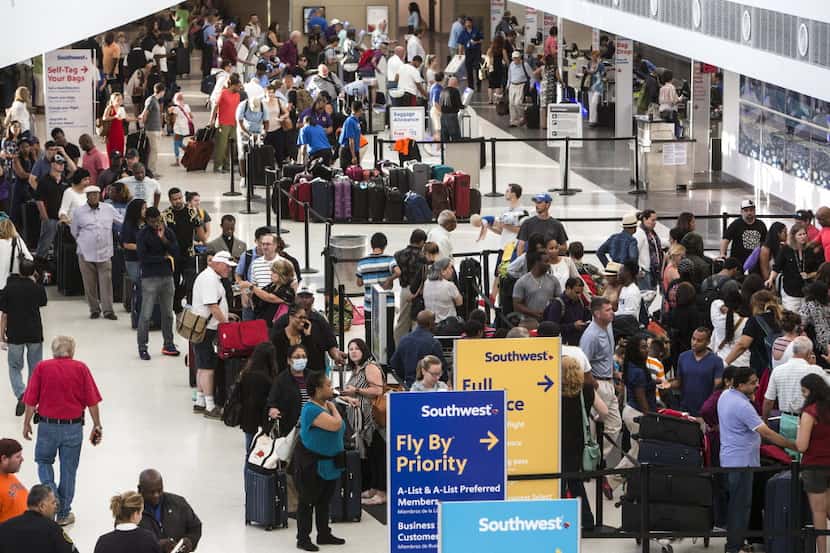 Southwest Airlines passengers stood in long lines July 21 at the ticketing/checking counter...