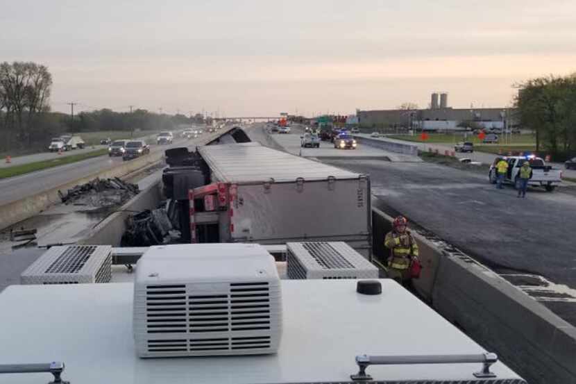 The 18-wheeler rolled over in a construction zone, caught fire and spilled fuel onto the...