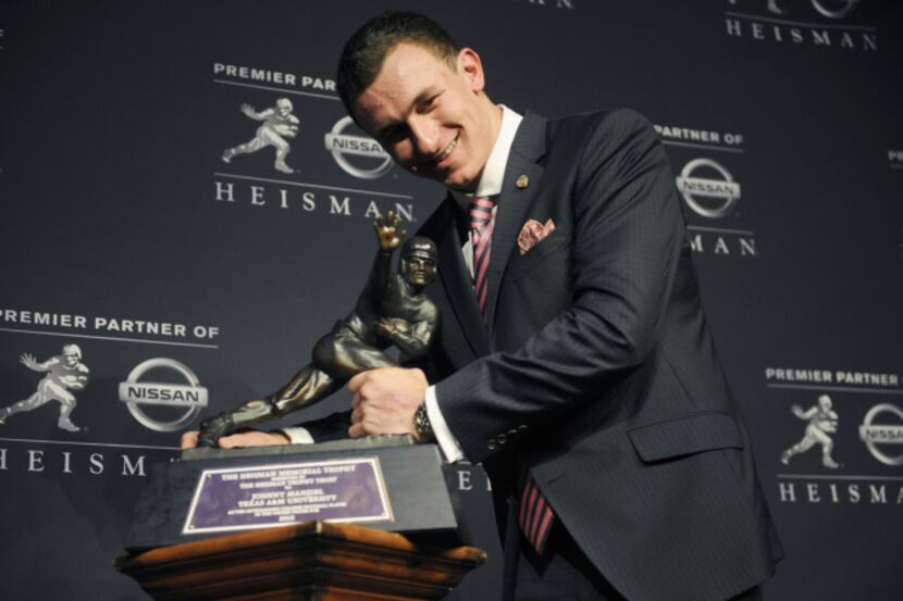 Texas A&M quarterback Johnny Manziel poses with the Heisman Trophy after becoming the first...