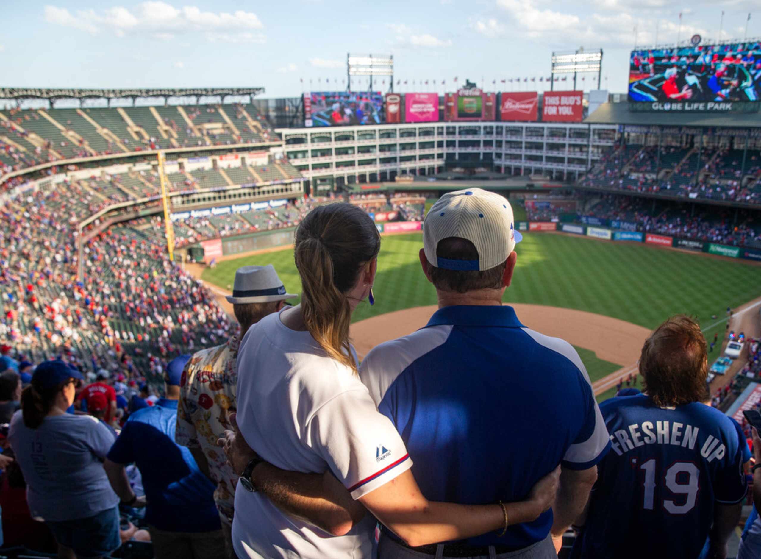 Kristen Tucker (left) hugs her father, Tommy Tucker, following the Texas Rangers' final game...