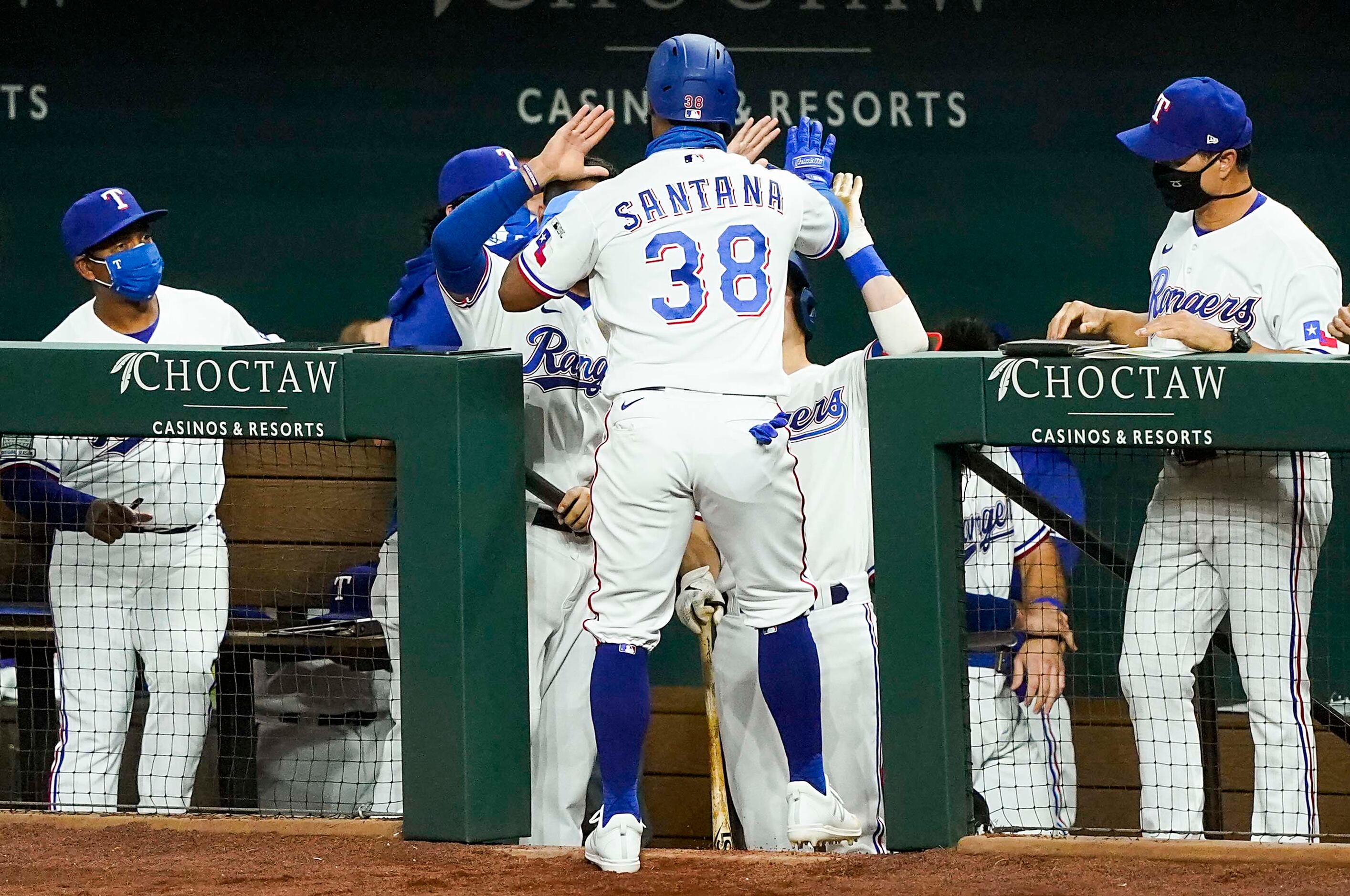 Texas Rangers outfielder Danny Santana celebrates with teammates after scoring on a a double...