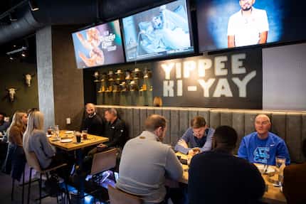 Customers eat as televisions play overhead in the new Cowboy Chow restaurant at the AT&T...