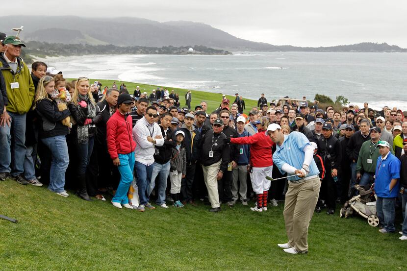 Dallas Cowboys quarterback Tony Romo chips the ball up to the 13th green of the Pebble Beach...