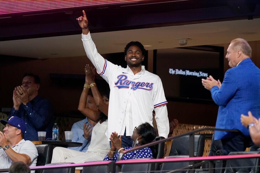 Texas Rangers' Kumar Rocker acknowledges applause from fans after being introduced on the...