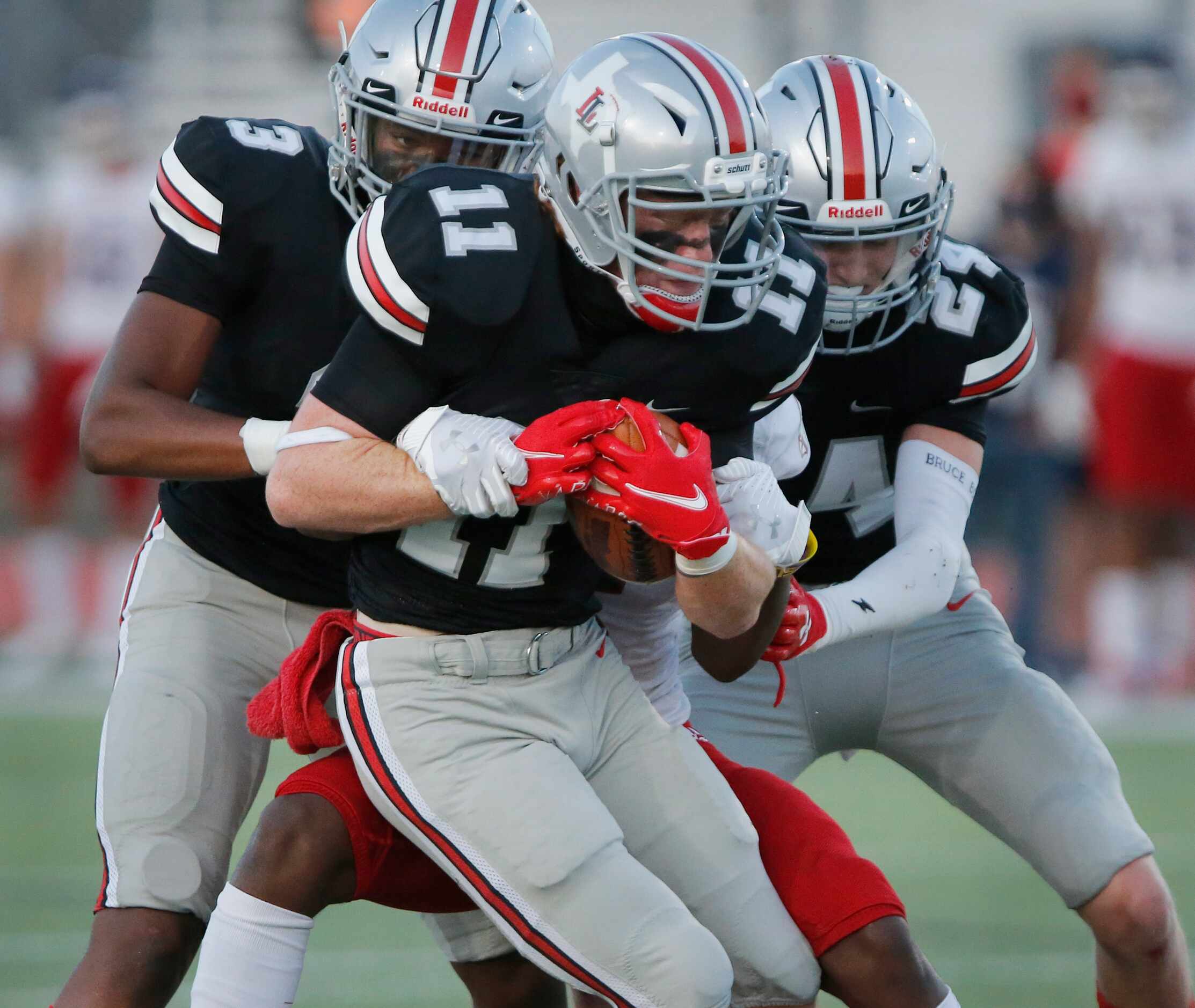 Lovejoy High School defensive back Chief Collins (11) is held up by John Paul II High School...