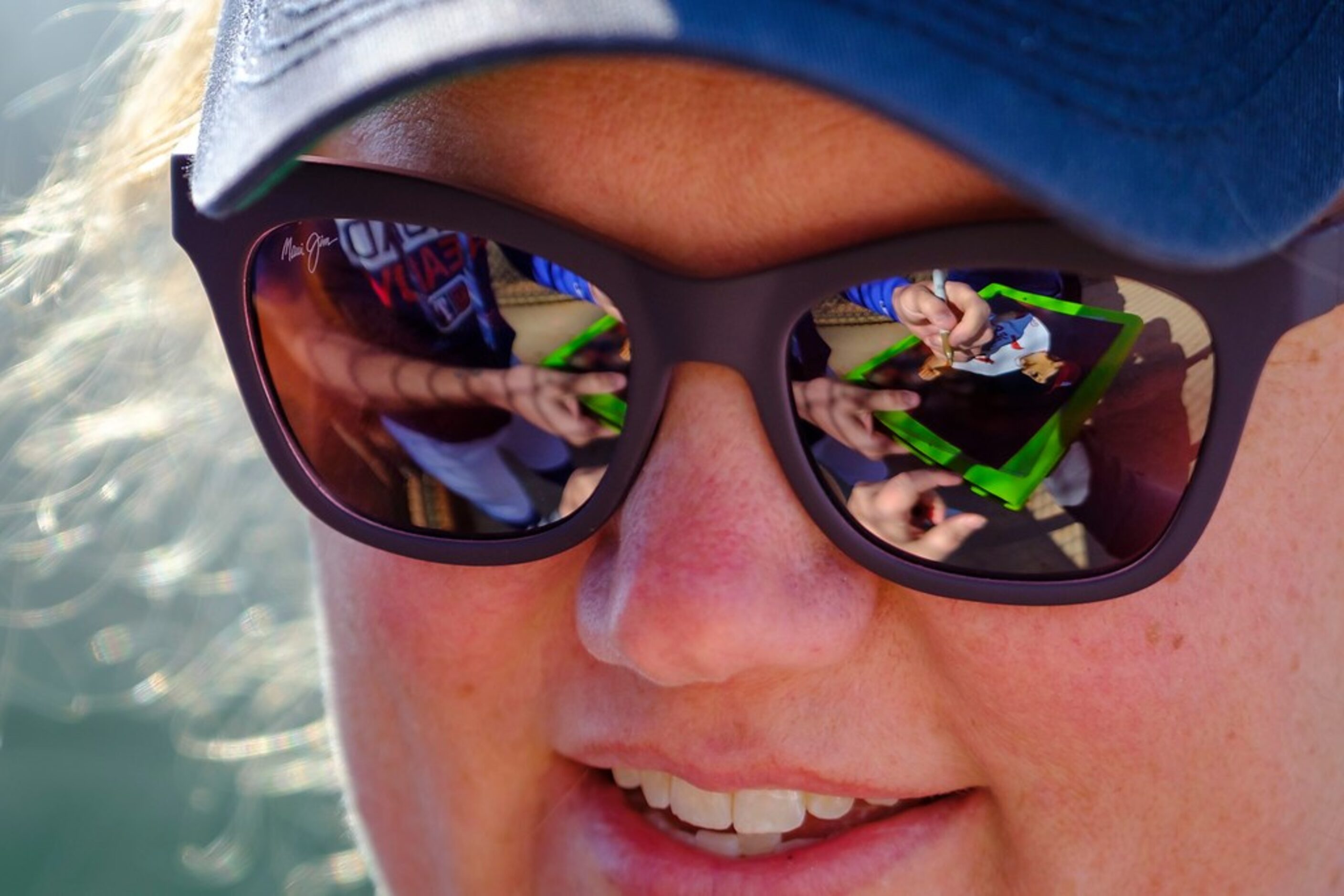 Texas Rangers pitcher Shelby Miller is reflected in the glasses of fan Rachel Clark as he...