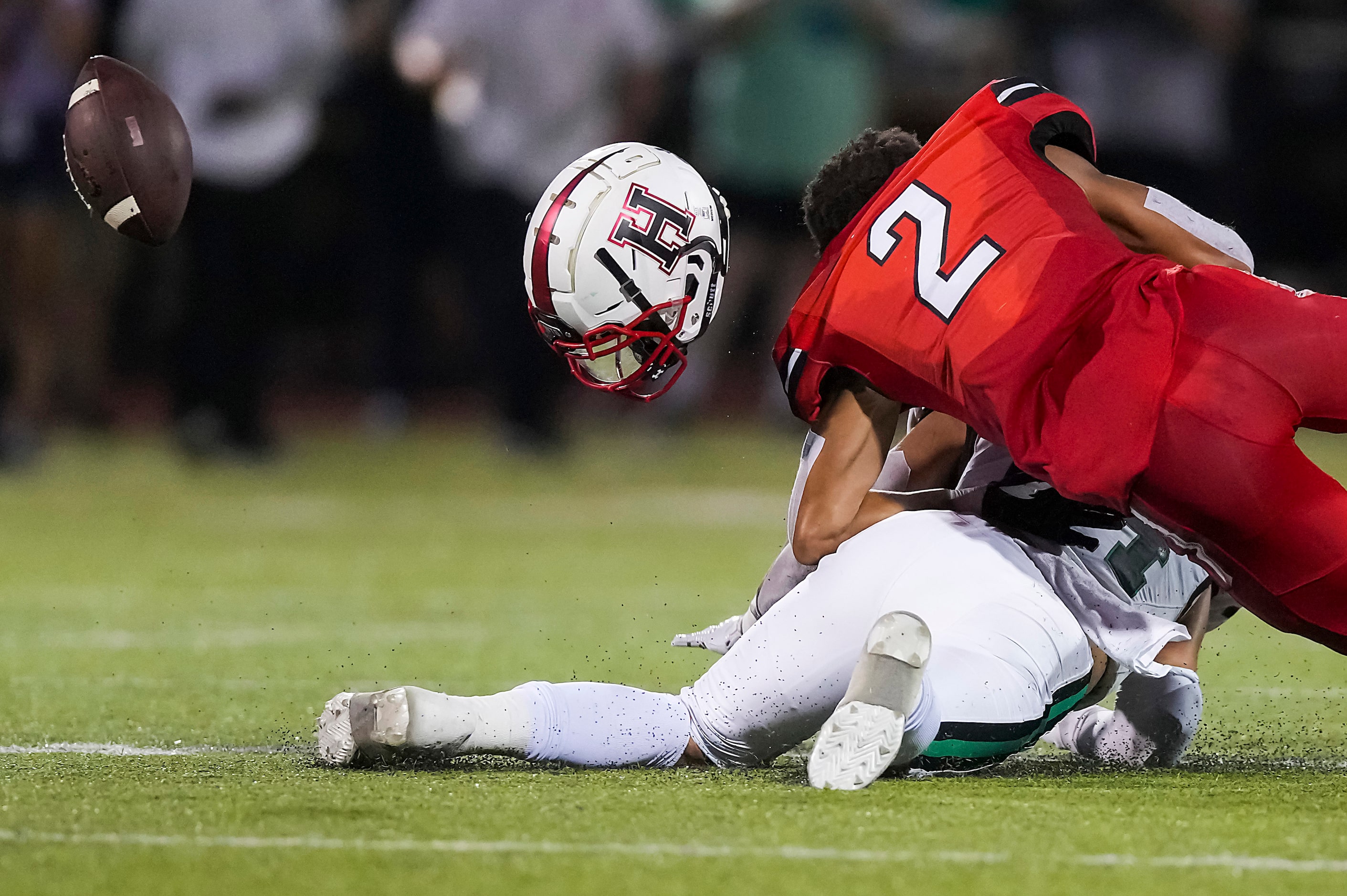 Rockwall-Heath wide receiver Jordan Nabors (2) loses his helmet while the ball flies away as...