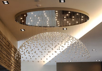 A chandler shaped like a half moon hangs in the lobby of the new Renaissance Dallas at Plano...