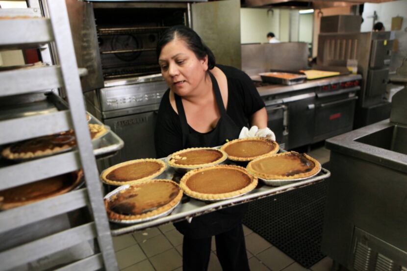 Salvation Army worker Teresa Flores loads a tray of pumpkin pies for the shelter's annual...