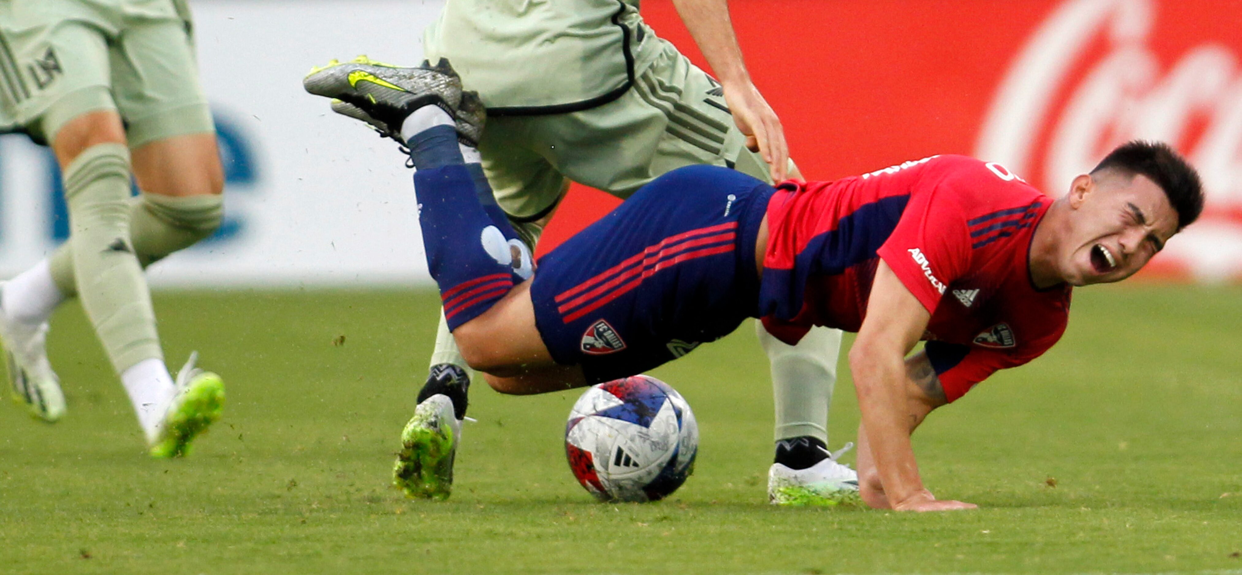 FC Dallas attacker Alan Velasco (20) grimaces as he takes a hard fall after colliding with a...