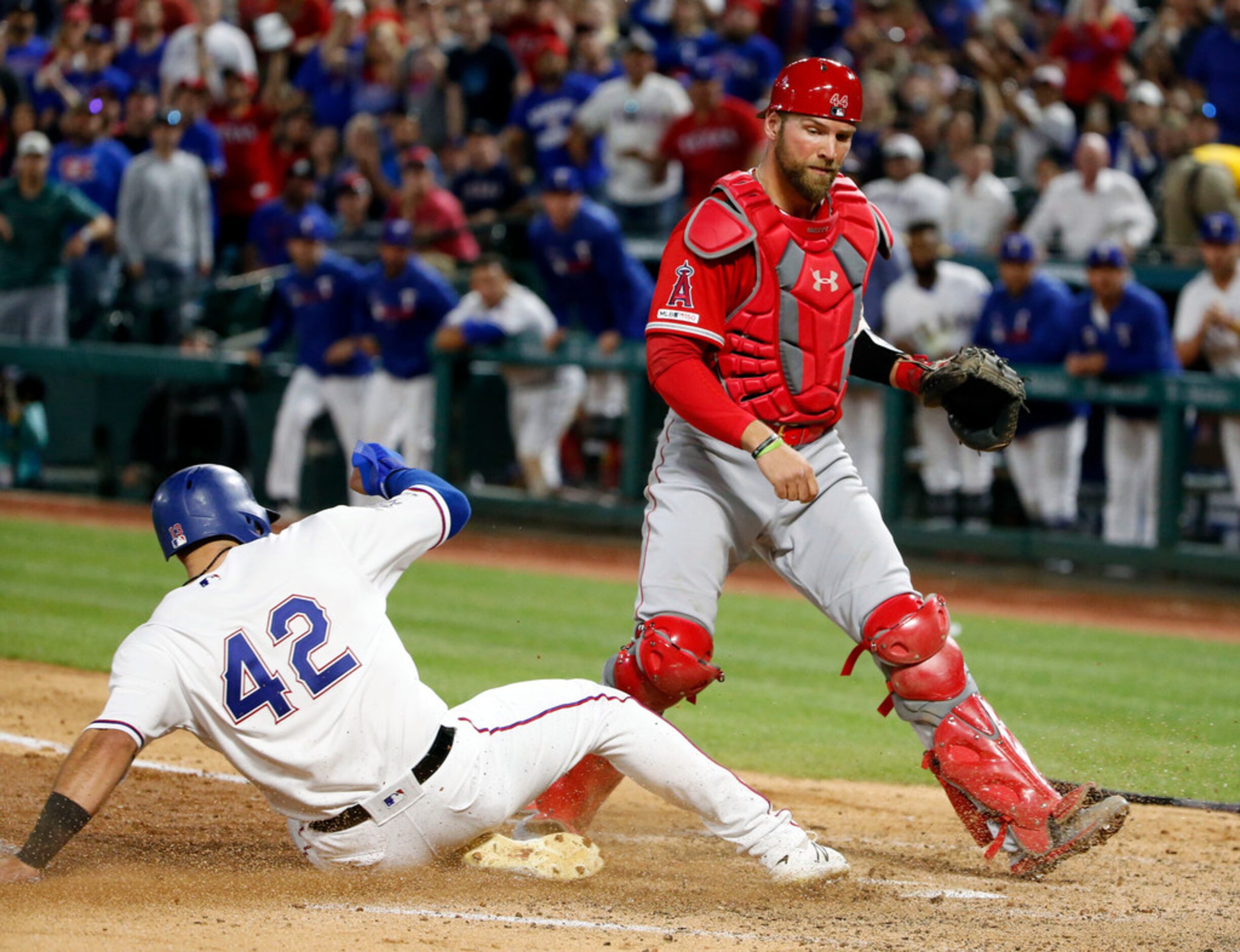 Texas Rangers' Joey Gallo, left, scores in front of Los Angeles Angels catcher Kevan Smith,...