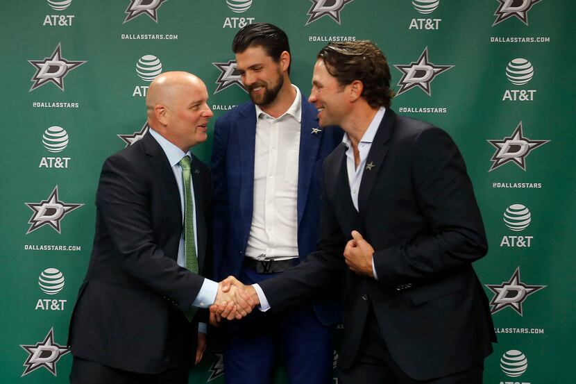 New Dallas Stars head coach Jim Montgomery, left, shakes hands with Brenden Morrow, right,...