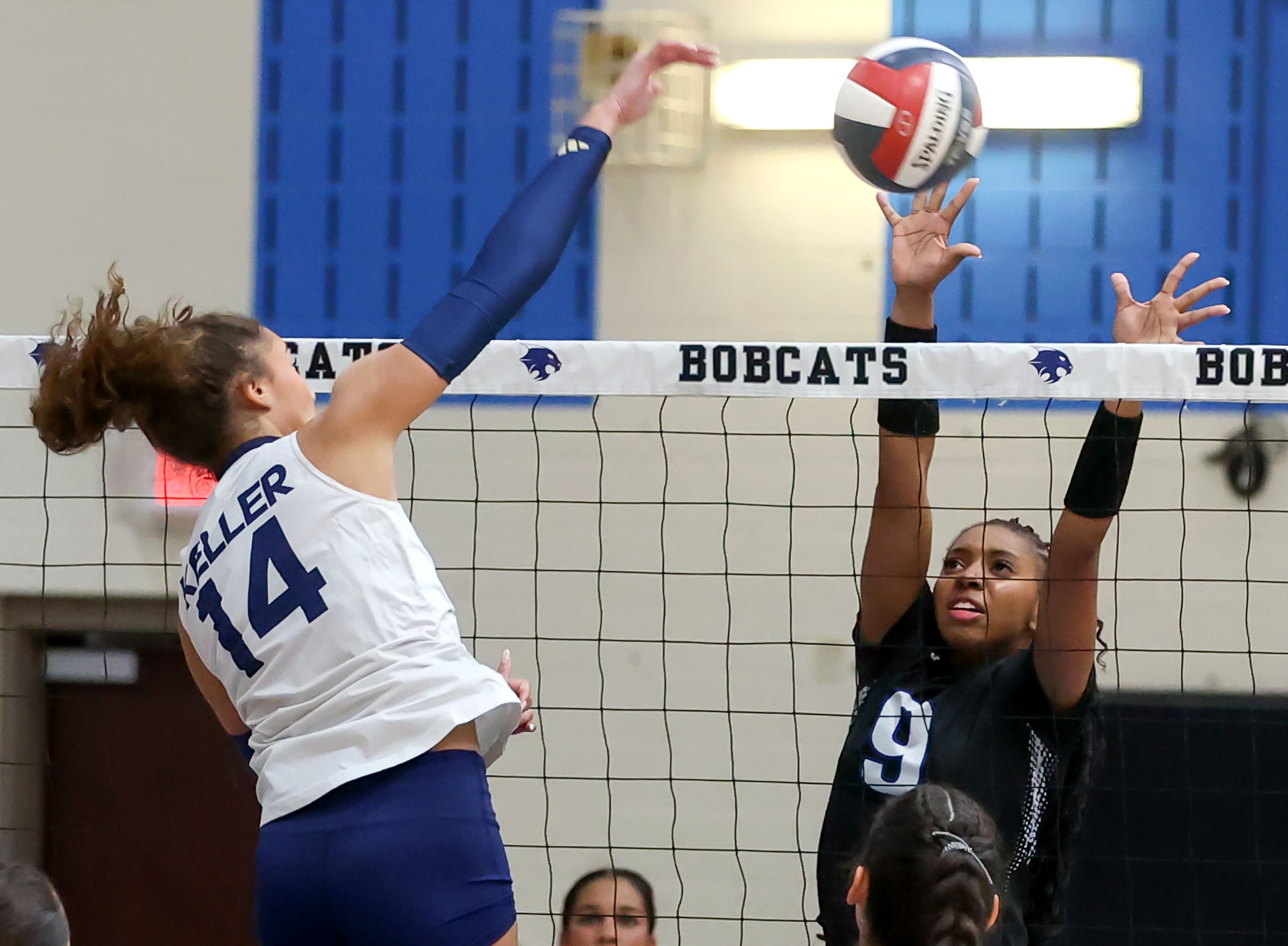 Keller's Sophee Dean (14) tries to get a kill past Byron Nelson's Zion Coats (9) during a...