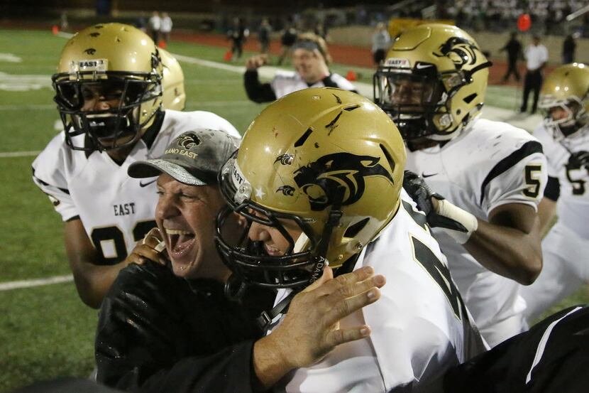 Plano East head coach Joey McCullough (bottom left) celebrates with his team after a high...