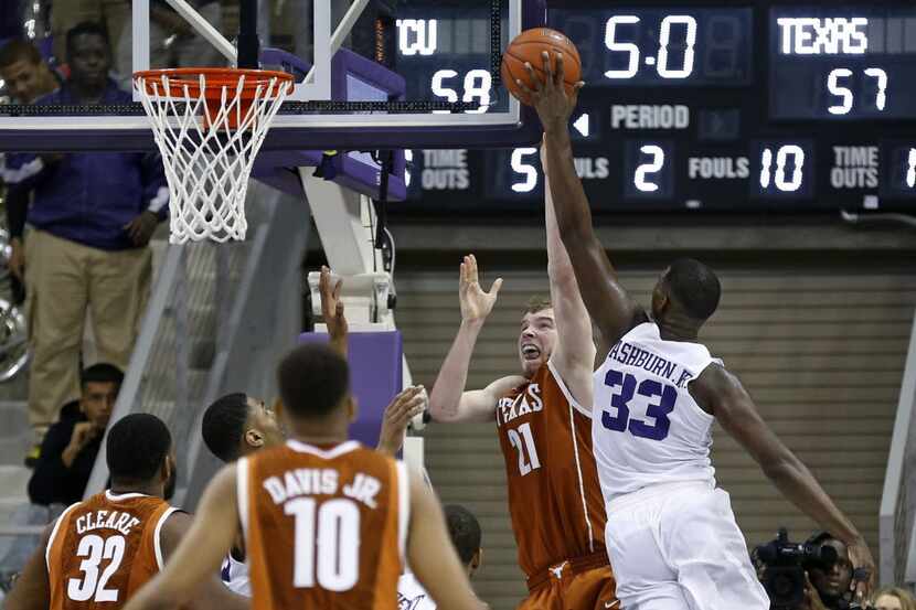 TCU forward Chris Washburn (33) blocks the shot of Texas forward Connor Lammert (21) with...