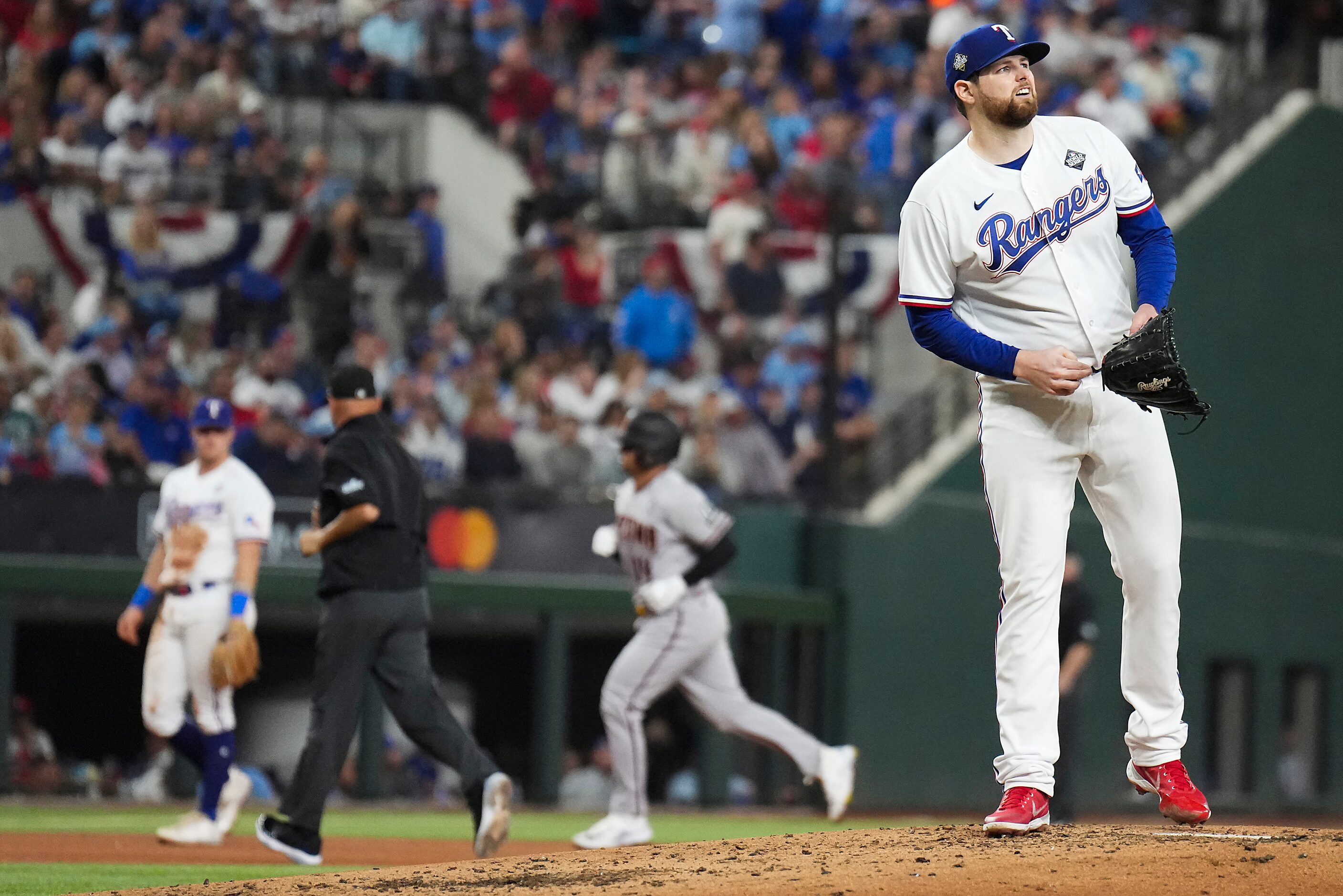 Texas Rangers starting pitcher Jordan Montgomery reacts after giving up a solo home run to...