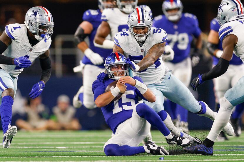 Giants quarterback Tommy DeVito slides for a first down as Cowboys defensive end Sam...