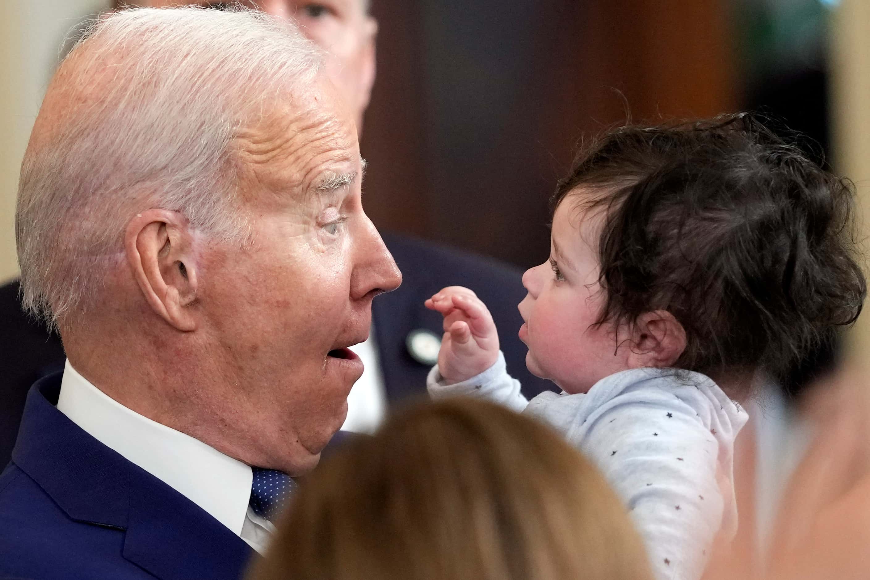 President Joe Biden reacts as he holds Hodge, son of Rep. Jimmy Gomez, D-Calif., after Biden...