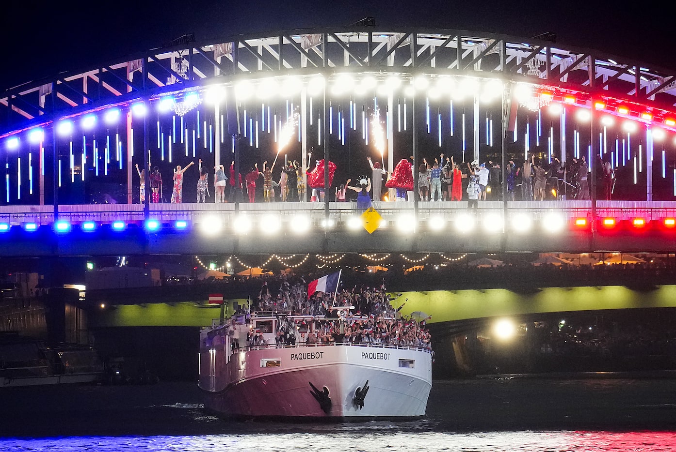 The boat carrying the host French delegation passes under performers on La Debilly...